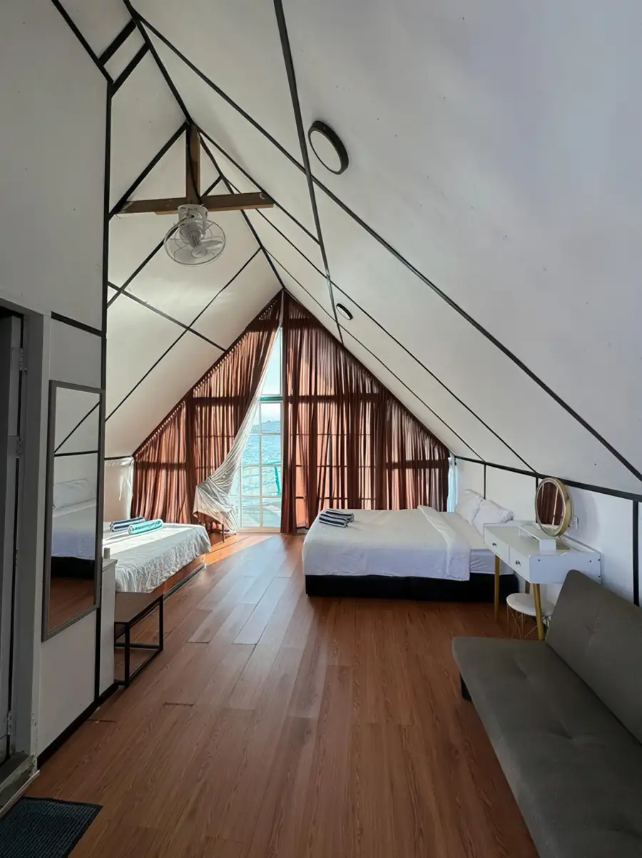 Spacious bedroom interior at Adil Waterhouse Resort with two queen beds and an A/C unit where sliding glass doors offer direct access to your private balcony near the island of Semporna.