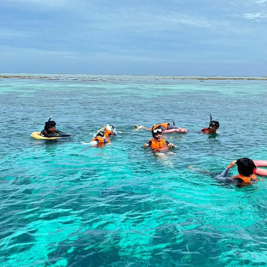 Surface snorkeling in turquoise waters near the resort Adil Waterhouse Resort