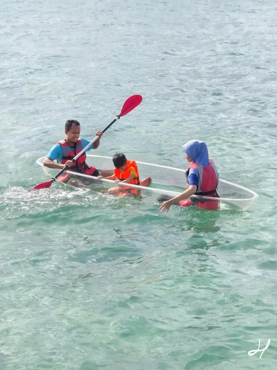 Leisure sea kayaking in transparent kayaks over the reef Adil Waterhouse Resort